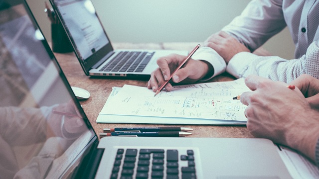 Two people are working on a business improvement plan