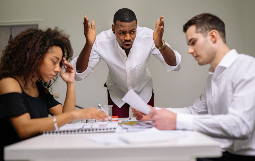 A business owner arguing with employees, showing why protecting your business from inflation is so important