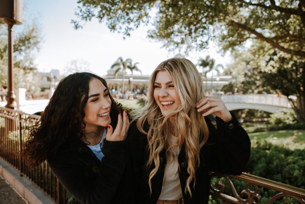 A friend smiling with another friend showing how to bounce back from business rejection.